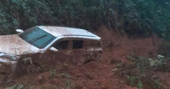 Ô tô 7 chỗ màu trắng bị đất, đá vùi lấp