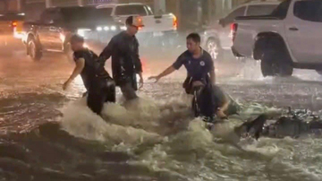 Mưa lớn nước chảy trôi người và xe máy trên quốc lộ 1 ở Đồng Nai