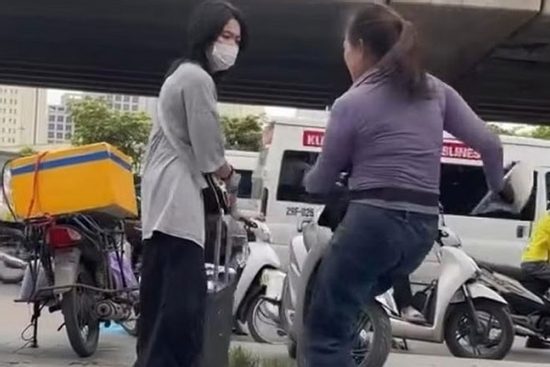 Người phụ nữ bán nước ở bến xe Mỹ Đình xua đuổi, đá hành lý của cô gái đợi xe trên vỉa hè