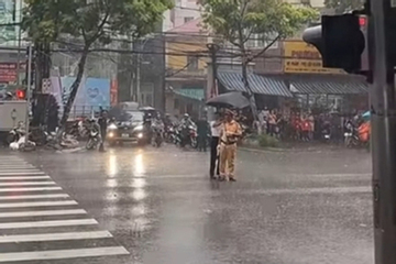 Clip 14 giây lan toả trên mạng: Người phụ nữ che ô cho chiến sĩ CSGT giữa mưa lớn tại lễ diễu binh