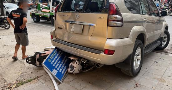 Ô tô Prado lùi trên đường Hà Nội, cuốn xe máy chở 2 phụ nữ vào gầm