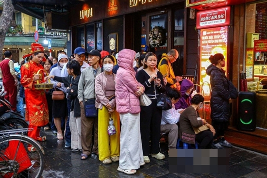Người dân đội mưa xếp hàng chờ mua vàng trước ngày vía thần Tài