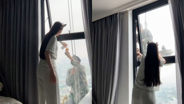 Mát lòng cảnh cô gái mời nước anh thợ treo mình giữa trời nóng lau kính cao ốc