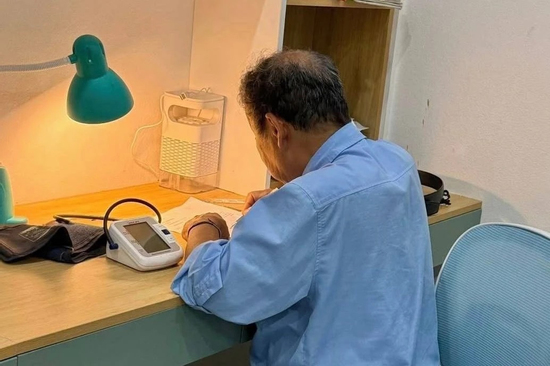 Ông 78 tuổi đặt máy đo huyết áp bên cạnh, kiên trì kèm cháu ôn thi vào lớp 10